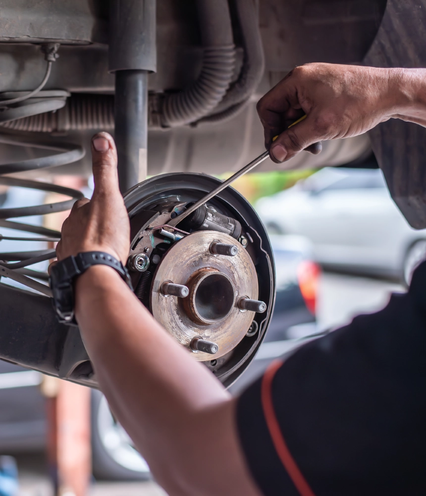 A person working on the front brake of a car.