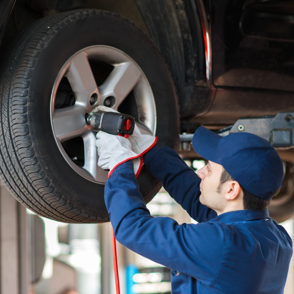 A man working on the tire of his car.