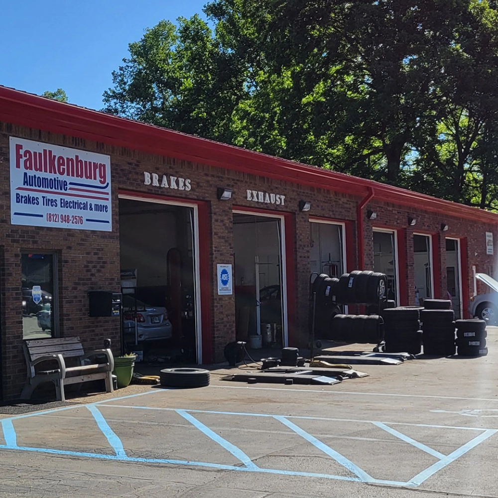 A red building with many tires on the side of it.