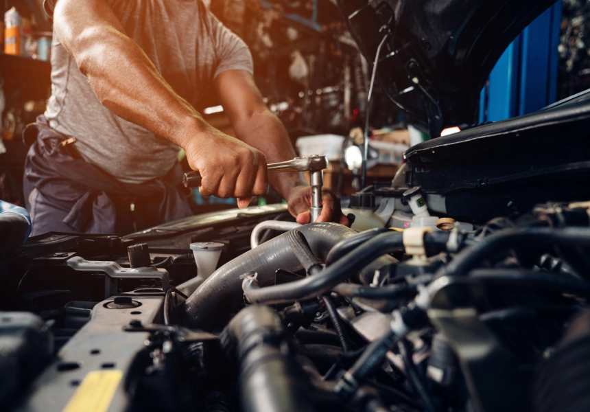 A man working on the engine of an automobile.