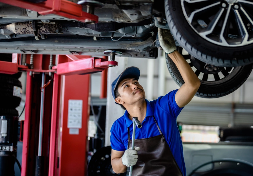 A man working on the bottom of a car tire.