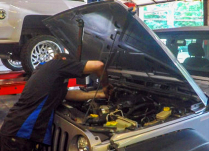 mechanic working on vehicle engine